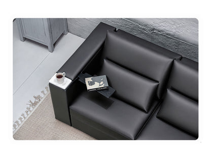 Black vegan leather sectional sofa with a small table and coffee on the white marble cupholder