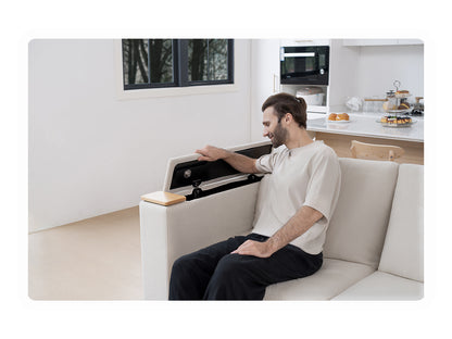 Man using a tray table integrated into the smart sofa in a modern living room.