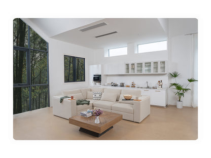 Cream Rezy Smart Sofa in an L-shaped modular sectional layout in a bright open-plan living room with floor-to-ceiling forest windows