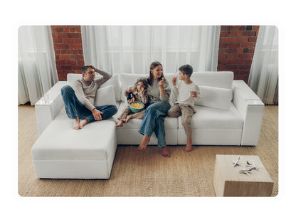 Family of four relaxing together with popcorn on a white Rezy Smart Sofa in a cozy living room
